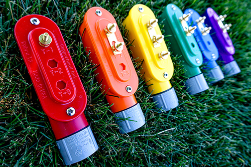 Cobra access points in red, orange, yellow, green, blue, and purple laying in the grass