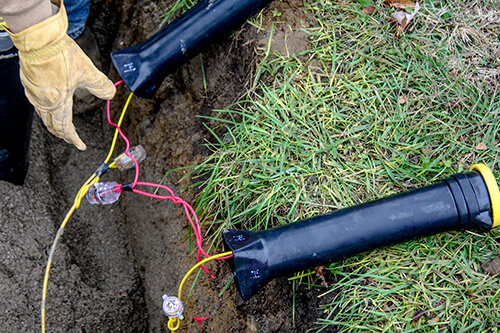 Two SnakePit access points connected to yellow tracer wire connected by a SnakeBite locking connector