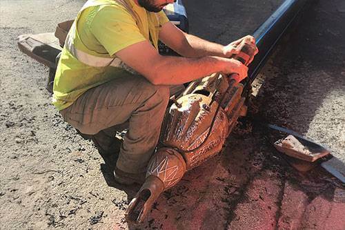 Construction worker adding tracer wire to pipe