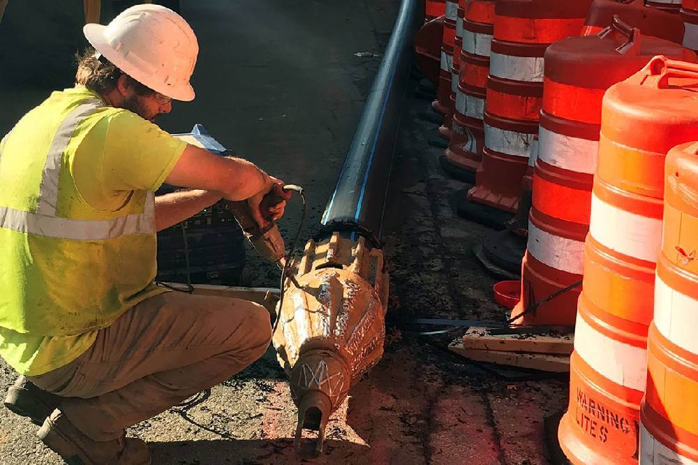 Man with a drill working on a pipe