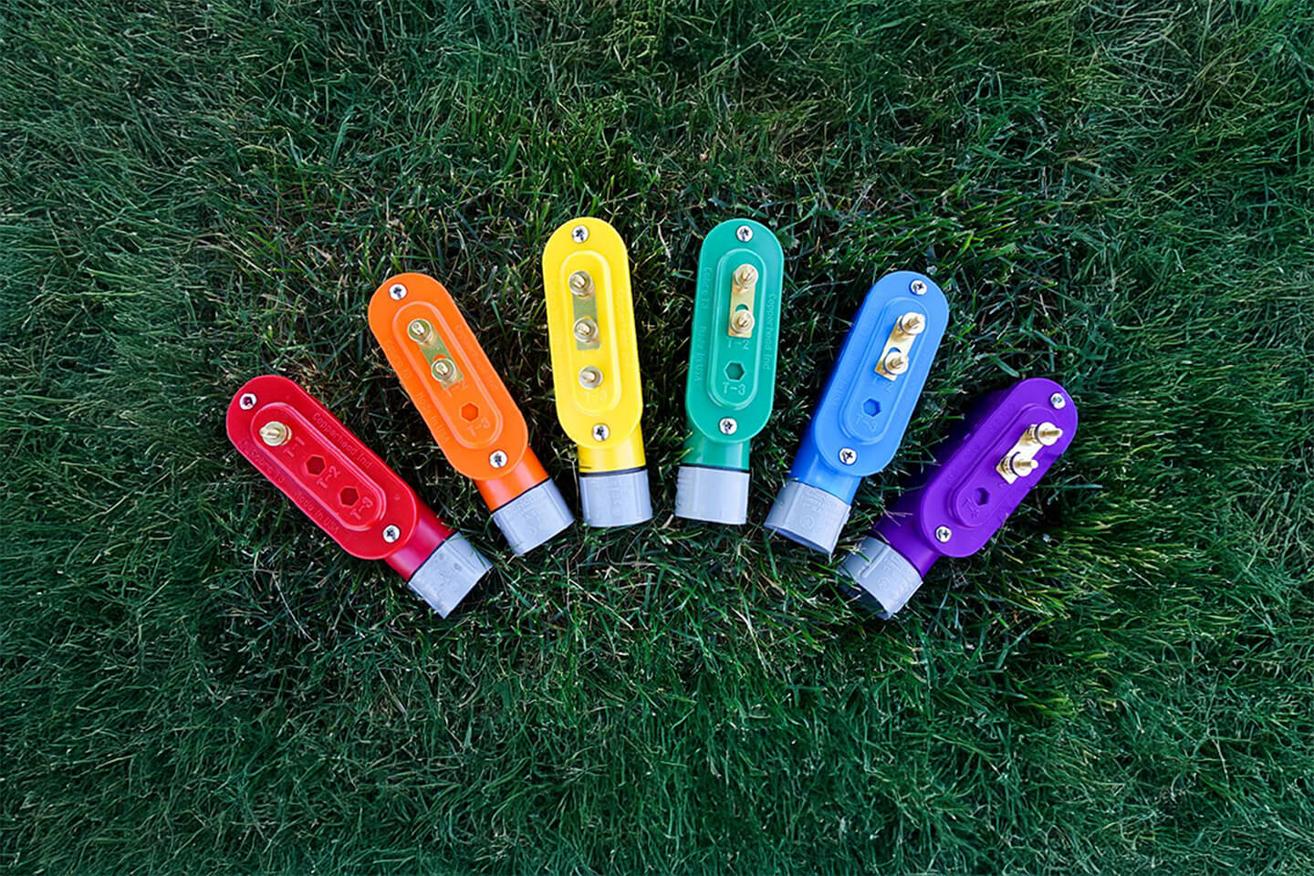 Cobra access points sitting in the grass in red, orange, yellow, green, blue, and purple